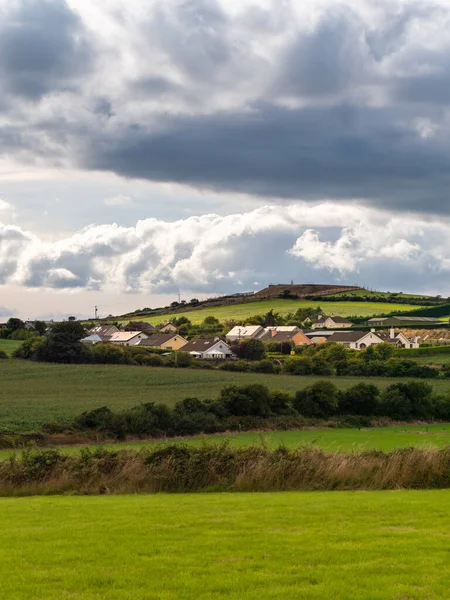 夏の夜に小さなアイルランドの村の上に積雲と空 アイルランド人の入植地 郡コルク 劇的な風景です ヨーロッパの田舎 素朴な風景です 雲の下の緑の草原 — ストック写真