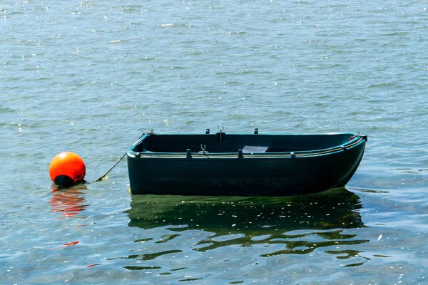 一只小塑料船在水面上 船边水面上的橙色浮标 船身上的船 — 图库照片