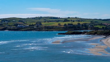 Güneşli bir yaz gününde ünlü İrlandalı Inchydoney plajı manzarası. İrlanda 'nın güzel Atlantik kıyıları. Yazlık tatil köyü, manzara, deniz manzarası. Açık deniz kıyısı
