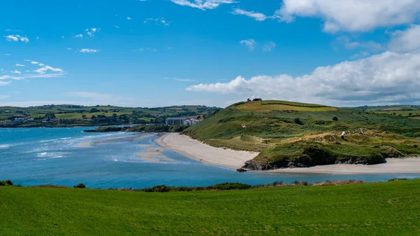 晴れた夏には インチドニー島と有名なアイルランドのビーチの緑の丘 アイルランド沿岸の白い雲と澄んだ青い空 アイルランドの夏の風景 水の近くの緑の草原 — ストック写真