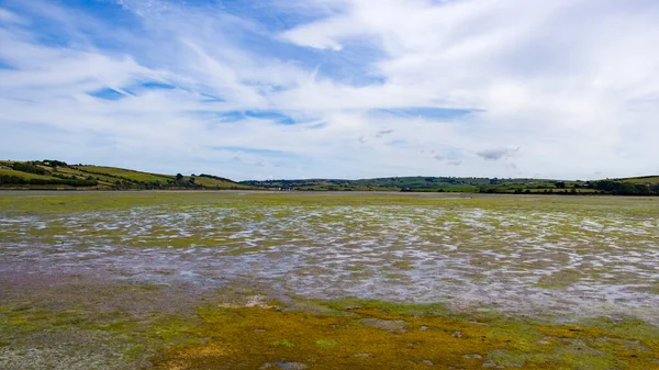 Vast tidal plains in the of Ireland on a summer day. Irish landscape. A tidal marsh which floods and drains by the tidal movement of the adjacent estuary, sea or ocean. tidal wetland