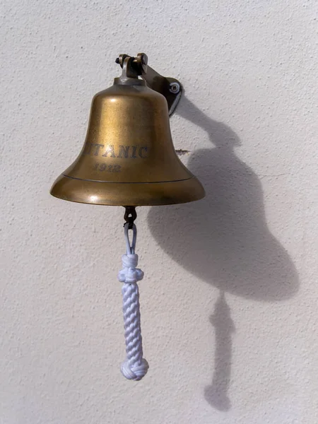 タイタニック号と1912年の日付の小さな鐘 白い壁に真鍮の鐘 — ストック写真