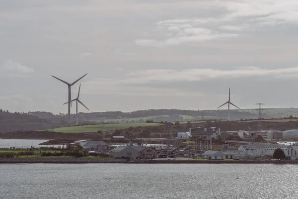 Cobh, İrlanda 'dan sanayi binaları ve rüzgar tarlalarının manzarası.