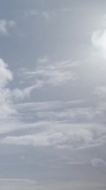Kümülüs bulutları gökyüzünde kabarık beyaz pamuk toplarına benzerler. Dikey video.