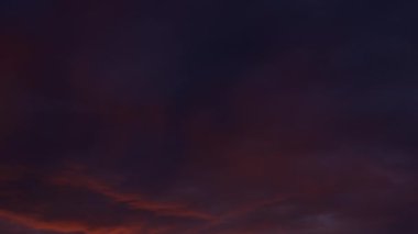 Şafak söktü. Kırmızı bulutlar, güçlü kırmızı ve pembe çizgiler gündoğumunda veya günbatımında uzun bulutların ışığı yansıttığını gösteriyor. Kanın arka planı, akşam gökyüzü ve bulutlar. Arkaplan olarak dramatik gökyüzü.