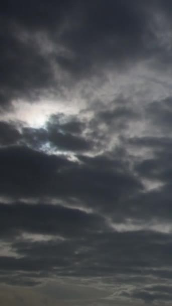太陽は厚い灰色の雨の雲を通して輝いて 空の背景のようなものです ビデオのタイムラプス ストラトコーム雲は しばしば暗いハニカム状の外観を持つ灰色または白色のパッチ状の雲です — ストック動画