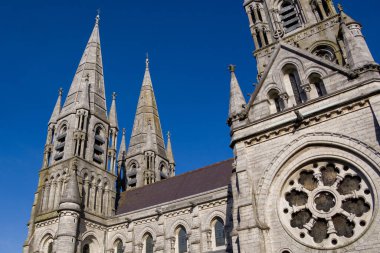 İrlanda 'nın Cork kentindeki St. Fin Barre Anglikan Katedrali' nin kuleleri. Neo-Gotik tarzında bir Hıristiyan kilisesi. Bulutsuz gökyüzü, kilise. Hıristiyan dini mimarisi.
