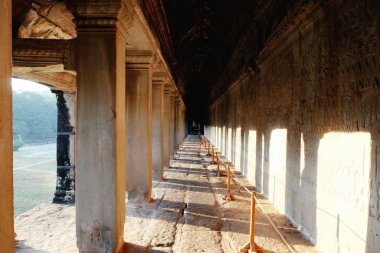 Antik Kamboçya Angkor tapınağında sütunları olan uzun bir koridor manzarası.