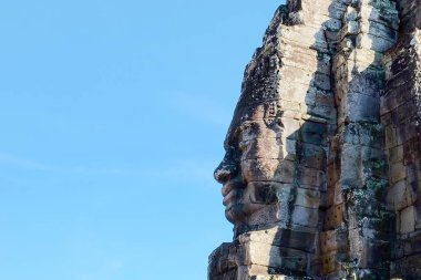 Taş bir yüz, gülümseyen bir Kamboçya heykeli..