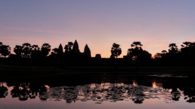 Günbatımında Kamboçya manzarası, ünlü Angkor Tapınağı 'nın belirgin siluetinin yer aldığı huzur dolu bir manzaradır..