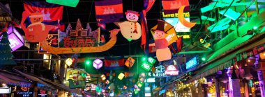 Siem Reap, Kamboçya, 23 Aralık 2018. Kamboçya 'nın tanınmış Pub Caddesi' nde gece vakti asılı duran şenlikli Noel süsleri ve çelenkleri..