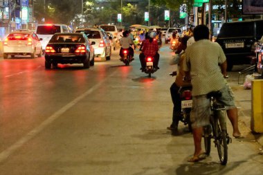 Siem Reap, Kamboçya, 23 Aralık 2018. Görüntü, Asyalı bir şehir caddesinde gece vakti trafik sıkışıklığı çeken arabaları ve motosikletleri gösteriyor..