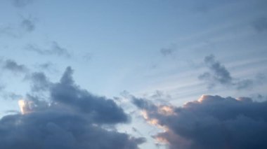 Güneşin aydınlattığı güzel bulutlar sabah gökyüzünde hızla uçuyor. Arka planda kümülüs bulutlar, video zaman dilimi..
