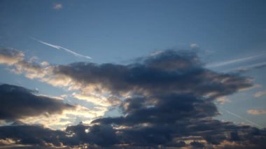 Güneş tarafından aydınlatılan tüylü kümülüs bulutları mavi sabah gökyüzünde hızla uçuyor. Arka plan olarak değiştirilebilir bulutlar, video zaman dilimi..