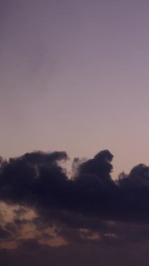 Büyüleyici bir video zaman diliminde, alışılmadık lavanta gökyüzü, gökyüzünü hareket ve güzellikle dolduran hızlı uçan bulutlar için romantik ve rüya gibi bir zemin görevi görür. Dikey video.