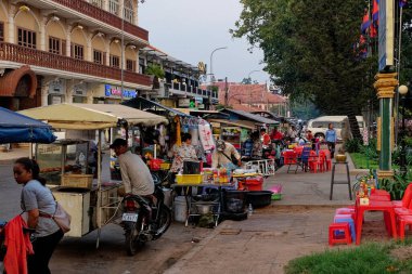 Siem Reap, Kamboçya, 22 Aralık 2022. Canlı Pazar Sahnesi: Kamboçya 'da satıcıların alışveriş arabalarının etrafında toplandığı renkli bir sokak pazarının canlılığını deneyin.