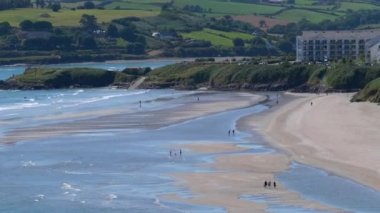 İrlanda 'nın County Cork kentindeki Inchydoney plajı güneşli bir günde altın kumu ve turkuaz sularıyla ünlüdür..