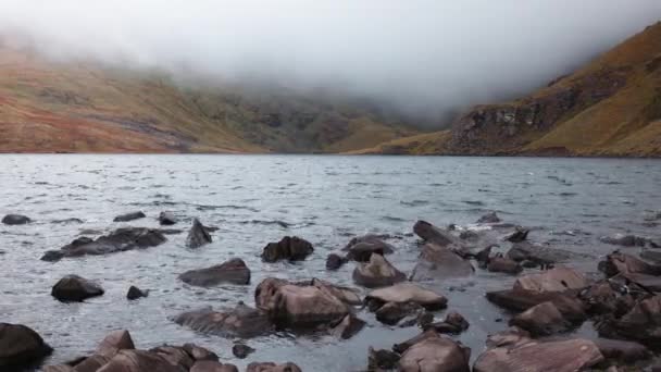 朦胧的早晨 在一个迷人的爱尔兰湖畔 四周笼罩着低云和散落在岸边的石头 — 图库视频影像