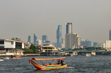 Bangkok, Tayland, 26 Aralık 2018. Arka planda şehir silüeti olan bir nehirde renkli bir tekne. Tekne geleneksel bir Tayland uzun kuyruklu teknesi..