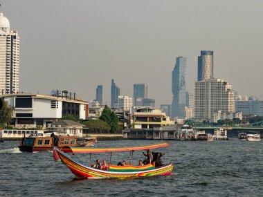 Bangkok, Tayland, 26 Aralık 2018. Tekne yolcu taşıyor. Nehir Chao Phraya Nehri 'dir. Ufuk çizgisi modern gökdelenlerden ve yüksek binalardan oluşuyor..