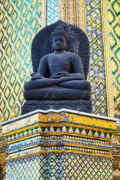 고요한 부처의 기지에 앉아있는 어두운 동상은 하늘색의 복잡한 디자인의 활기찬 — 스톡 사진