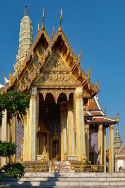 Altın ve kobalt süslemeleriyle bezenmiş zengin bir Tayland ibadethanesi yüksek bir kule sergiliyor..