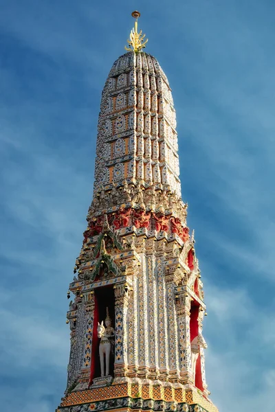 stock image A temple in Thailand. The temple is a tall, ornate structure with many levels and intricate details. The temple is made of stone. The sky is clear blue.