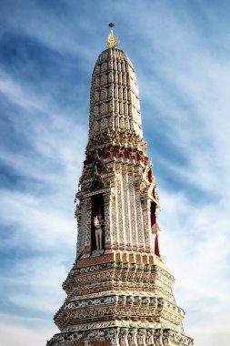 Tayland 'da bir tapınak. Tapınak uzun, süslü bir yapıdır. Birçok katmanı ve karmaşık ayrıntıları vardır. Tapınak taştan yapılmıştır. Gökyüzü açık..
