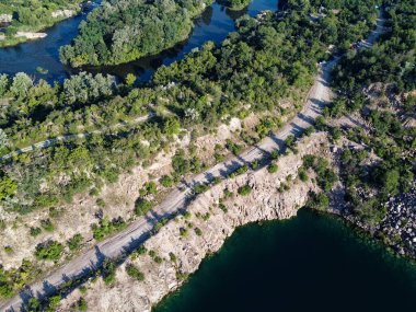 Güneşli bir yaz sabahında Radon Gölü 'nün Rocky kıyısında. Sel basmış eski bir granit ocağının hava manzarası. Resimli bir gölet..