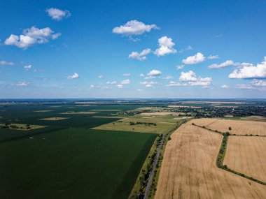 Güzel tarımsal manzara, açık arazi mavi gökyüzü ve beyaz bulutlar. Kuş bakışı tarlalar.
