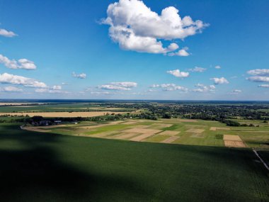 Güzel tarımsal manzara, açık arazi mavi gökyüzü ve beyaz bulutlar. Kuş bakışı tarlalar.