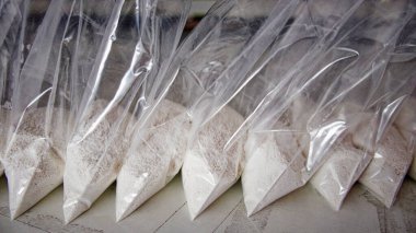 Beyaz tozla dolu saydam keseler. Küçük keselerde beyaz toz paketlenmiş..