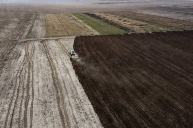 Traktör tarlayı sürüyor, hava manzarası var. Tarım arazisi.