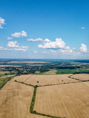 Güzel tarımsal manzara, açık arazi mavi gökyüzü ve beyaz bulutlar. Kuş bakışı tarlalar.
