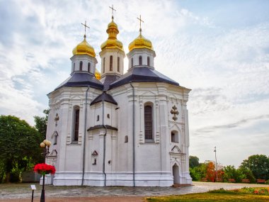 Altın kubbeleri ve haçları olan beyaz bir kilise, bulutlu mavi bir gökyüzünün zeminine kurulmuş. Ukrayna 'nın Chernihiv kentindeki Aziz Catherine Ortodoks Kilisesi' nin üzerinde güzel bir gökyüzü..