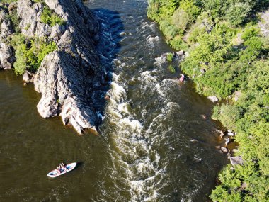 Yazın Ukrayna 'nın güneyindeki Bug Nehri' nde nehir eşiği yakınında bir tekne. Nehirde bir tekne kuş bakışı, manzara.