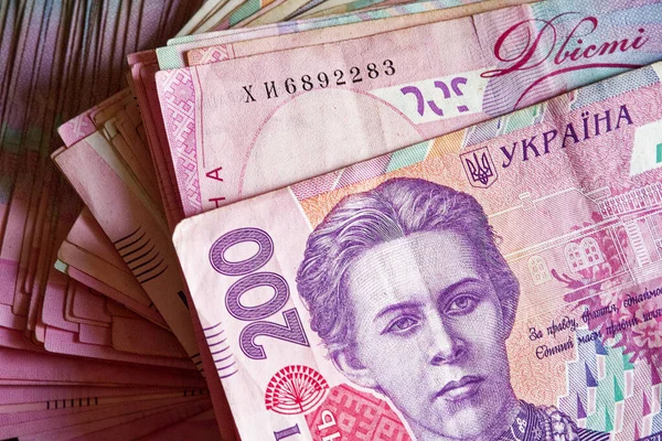 Bir yığın Ukrayna 200 Hryvnia banknotu, üzerinde bir portre var. İki yüz hryvnia değerinde bir avuç banknot. Ukrayna parası.