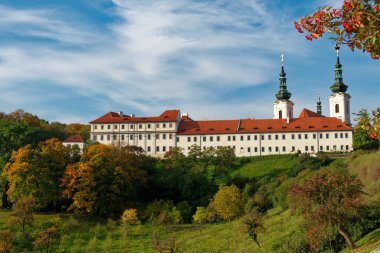 Strahov Manastırı, kırmızı çatılı beyaz bir bina, Prag 'da bir tepede yer alıyor..
