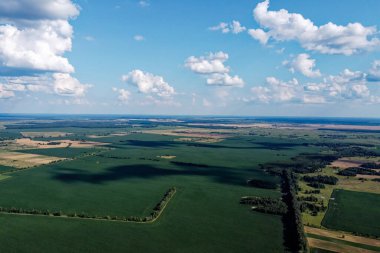 Güzel tarımsal manzara, açık arazi mavi gökyüzü ve beyaz bulutlar. Kuş bakışı tarlalar.