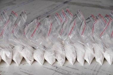 Beyaz tozla dolu saydam keseler. Küçük keselerde beyaz toz paketlenmiş..