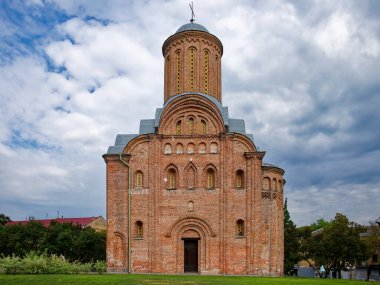 Chernigov, Ukrayna 'daki Pyatnitskaya Kilisesi, yüksek kulesi olan kırmızı tuğlalı bir bina, yeşil ağaçlar ve açık bir gökyüzü üzerine kurulmuştur. Chernihiv 'deki Cuma Kilisesi (St. Paraskevi Cuma günü Torg' da).