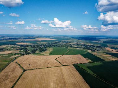 Güzel tarımsal manzara, açık arazi mavi gökyüzü ve beyaz bulutlar. Kuş bakışı tarlalar.