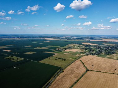 Güzel tarımsal manzara, açık arazi mavi gökyüzü ve beyaz bulutlar. Kuş bakışı tarlalar.