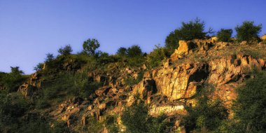 Pürüzlü kayalar yemyeşil bir günde yemyeşil ortamda çıkıyorlar.