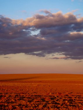 Arazi kayalık, gökyüzünde bulutlar toplanıyor..
