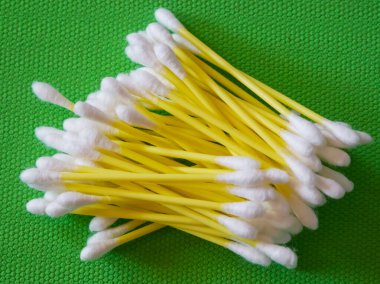 Cotton Swab Dizisi. Sarı saplı beyaz uçlu çubuklar, yeşil arkaplan.