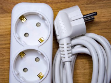 Tahtadaki elektrik prizi ve soketi güç kaynağı ve enerji kavramını gösteriyor..