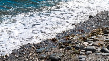 Okyanus dalgaları kayalara çarpıyor, güzel ve huzurlu bir manzara yaratıyor. Su koyu mavi renktedir ve kayalar sahilin dört bir yanına dağılmıştır. Manzara huzurlu ve rahatlatıcı..