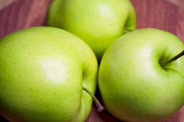 Yeşil elmalar, canlı ve taze, sağlıklı beslenme üzerine eğitici materyaller için uygun olan bu görüntüye hakimdir..