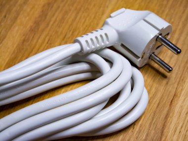 Nizhyn, Ukrayna, 25 Eylül 2021. Görüntü beyaz bir elektrik kablosu ve ahşap fişi gösteriyor, bağlantı ve güç kaynağını temsil ediyor. İllüstrasyon Editörü.